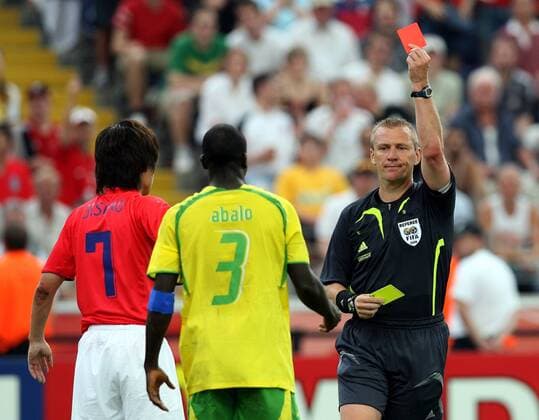 FIFA Schiedsrichter Graham Poll (England) zeigt Jean-Paul Abalo (Togo, Mitte) Gelb Rot, daneben Park Ji Sung (Südkorea) - Fußball WM Herren WM 2006, Länderspiel, Nationalteam, Nationaltrikot, Gruppe G, Südkorea - Togo 2:1 Korea Gruppe Frankfurt M. Fußball WM Herren WM 2006, Länderspiel, Nationalteam, Nationaltrikot, Gruppe G, Südkorea - Togo 2:1 Korea Gruppe Frankfurt M.
