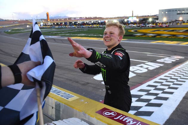 LAS VEGAS, NV - MARCH 05: Ty Gibbs ( 54 Joe Gibbs Racing Monster Energy Toyota) receives the Sunoco checkered flag as he celebrates winning the race during the NASCAR, Motorsport, USA Xfinity Series Alsco Uniforms 300 on March 05, 2022, at Las Vegas Motor Speedway in Las Vegas, NV. (Photo by Chris Williams Icon Sportswire) AUTO: MAR 05 NASCAR Xfinity Series - Alsco Uniforms 300 Icon0072203051195