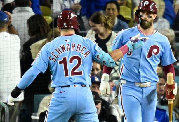 Philadelphia Phillies designated hitter Kyle Schwarber (12) celebrates with Bryce Harper after hitting a two-run home run in the eighth inning against the Los Angeles Dodgers during game three of the MLB, Baseball Herren, USA National League Division Series at Dodger Stadium in Los Angeles, California, on Wednesday, October 8, 2025. LOS20251008930 JOHNxMCCOY