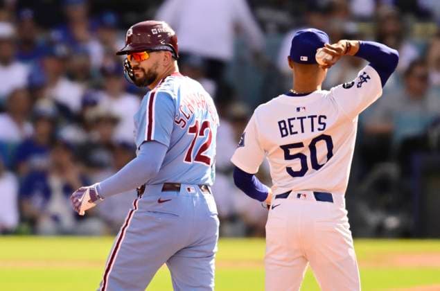 Philadelphia Phillies designated hitter Kyle Schwarber (12) stands on second base after hitting a double in the first inning as Los Angeles Dodgers Mookie Betts handles the ball during game four of the MLB, Baseball Herren, USA National League Division Series at Dodger Stadium in Los Angeles, California, on Thursday, October 9, 2025. LOS20251009901 JOHNxMCCOY