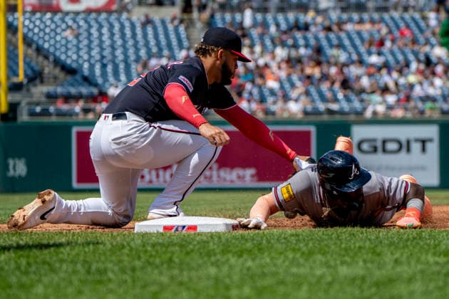 Atlanta Braves center fielder Michael Harris (23) slides into first base as Washington Nationals first baseman Luis Garcia Jr. (2) tags during the top of the fourth inning during a game at Nationals Park in Washington, DC on Thursday, April 23, 2026. WAP20260423318 BONNIExCASH