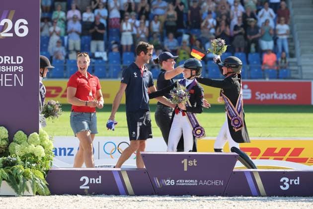 Awards ceremony with grooms standing alongside the riders, Grooms, Medals: 1st place Charlotte Fry GBR, Great Britain, United Kingdom, Horse Glamourdale, 2nd place: Cathrine Laudrup Dufour DEN, Denmark, Denmark, horse: Mount St John Freestyle, 3rd place, bronze: Katharina Hemmer GER, Germany, Germany, Denoix PCH, Dressage, FEI Dressage World Championship MEGGLE Prize, Grand Prix Special, Individual Classification, AACHEN FEI World Championships 2026, World Festival of Equestrian Sports, 2026 Equestrian World Championships, Aachen 2026, Welcome Home 2026, Aachen Soers, August 11–23, 2026, Equestrian Sports, August 14, 2026, Aachen Soers, Germany