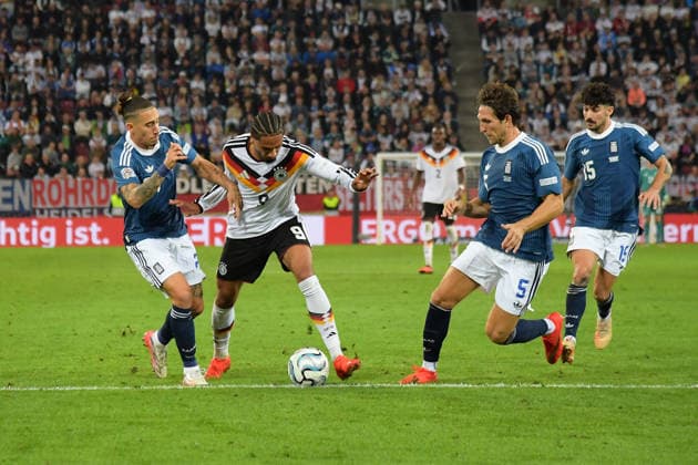 September 27, 2026, xemx, Soccer, UEFA Nations League, Germany vs. Greece, Konstantinos Kostas Tsimikas (Greece), Kevin Schade (German National Soccer Team, DFB), Panagiotis Retsos (Greece), tackle, action, battle for the ball, Augsburg