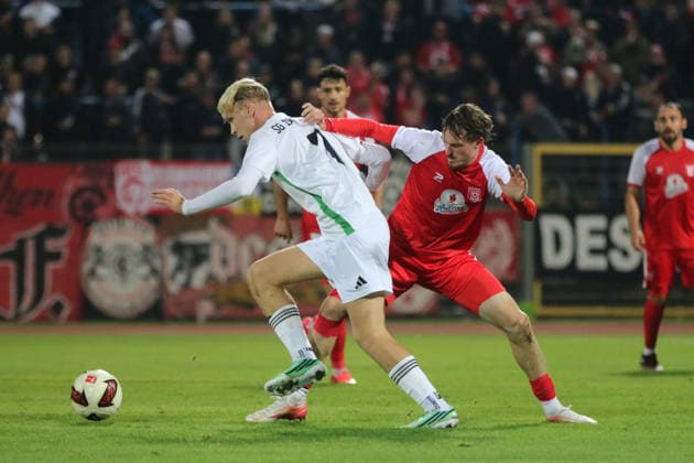 October 2, 2026 Men s Soccer 2026–2027 dachbleche24 State Cup, 2nd Round: SG Reppichau vs. Hallescher FC at Paul Greifzu Stadium, Dessau-Roßlau; Niklas Kastenhofer (Halle), 3, in red, in a tackle with Fernando Spremberg of Reppichau, 7, in white; Dessau-Roßlau, Saxony-Anhalt, Germany