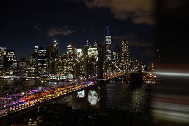 Bilder des Jahres 2021, News 03 März News Themen der Woche KW10 News Bilder des Tages (210315) -- NEW YORK, March 15, 2021 -- Images of New Yorkers lost to the COVID-19 pandemic are projected onto the Brooklyn Bridge in New York, the United States, March 14, 2021. New York City held an official memorial ceremony on Sunday evening to honor more than 30,000 New Yorkers who died of COVID-19. The total number of New Yorkers lost to the COVID-19 pandemic is more than that died from World War II, the Vietnam War, hurricane Sandy and 911 attacks put together, said New York City Mayor Bill de Blasio. ) U.S.-NEW YORK-COVID-19 VICTIMS-MEMORIAL CEREMONY MichaelxNagle
