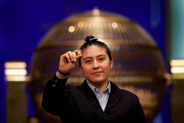 Bilder des Jahres 2021, News 12 Dezember News Themen der Woche KW51 A student from San Ildefonso school calls out number 86148 winner of the first prize during El Gordo traditional Spanish Christmas Lottery draw held in the Royal Theater in Madrid, Spain, 22 December 2021. The traditional Spanish Christmas Lottery El Gordo (The Fat One) will share out a total of 2.38 billion euros that will be divided in 15,304 prizes. The main prizes per ticket are, 400,000 euros for the first prize; 125,000 for the second; 50,000 for the third; 20,000 for the fourth; and 6,000 for the fifth. The big drum contains a total of 100,000 wooden balls with the lottery numbers, where the small one contains a total of 1,807 wooden balls with the prizes quantities. El Gordo traditional Spanish Christmas Lottery draw !ACHTUNG: N Copyright: xJUANxCARLOSxHIDALGOx GRAF1238 20211222-35e85abd9c013e8bfe87483a977a1131bc2182a8
