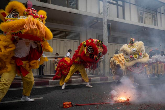 September 25, 2022, Bangkok, Bangkok, Thailand: Traditional Chinese lion dancers jump as fireworks explode in the street on the first day of the Vegetarian Festival. The annual Vegetarian Festival, which derives from Chinese religious influences, began today in cities throughout Thailand. Bangkokâ€⠢s historic Yaowarat Chinatown saw the start of the 11 day long event, with food stalls lining the streets selling vegan food. Bangkok Thailand - ZUMAt128 20220925_zap_t128_007 Copyright: xAdryelxTalamantesx