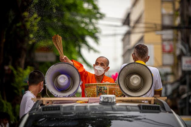 September 25, 2022, Bangkok, Bangkok, Thailand: A pickup truck slowly drives as a Buddhist monk splashes holy water on passersby on the first day of the Vegetarian Festival . The annual Vegetarian Festival, which derives from Chinese religious influences, began today in cities throughout Thailand. Bangkokâ€⠢s historic Yaowarat Chinatown saw the start of the 11 day long event, with food stalls lining the streets selling vegan food. Bangkok Thailand - ZUMAt128 20220925_zap_t128_009 Copyright: xAdryelxTalamantesx