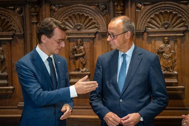Federal Chancellor Friedrich Merz signs the Golden Book of the City of Münster in the Peace Hall, with Hendrik Wüst, Minister President of North Rhine-Westphalia on the left , Chancellors inaugural visit to North Rhine-Westphalia Münster , Münster North Rhine-Westphalia Germany City Hall