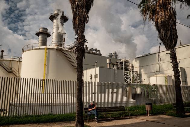 October 4, 2025, Sant Adria Del Besos, Barcelona, Spain: Man sits next to the chimneys of Combined cycle thermoelectric plant Besos Power Station located in Sant Adria del Besos, Barcelona, Spain and owned by Spanish multinational electric utility companies Naturgy and Endesa. Central termica del Besos, power plant, Sant Adria Del Besos Spain - ZUMAb137 20251004_fap_b137_006 Copyright: xJordixBoixareux