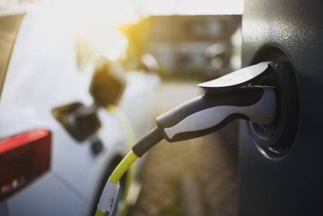 E-Auto mit Ladekabel und Stromstecker an einer Ladesäule angeschlossen bei Sonnenaufgang im Gegenlicht in einem Wohngebiet an der Straße, Schagen, Nordholland, Niederlande E-car with charging cable and power plug connected to a charging station at sunrise in backlight in a residential area on the street, Schagen, North Holland, the Netherlands Copyright: imageBROKER JanxTepass ibxjte17367684