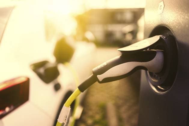 E-Auto mit Ladekabel und Stromstecker an einer Ladesäule angeschlossen bei Sonnenaufgang im Gegenlicht in einem Wohngebiet an der Straße, Schagen, Nordholland, Niederlande E-car with charging cable and power plug connected to a charging station at sunrise in backlight in a residential area on the street, Schagen, North Holland, the Netherlands Copyright: imageBROKER JanxTepass ibxjte17367687