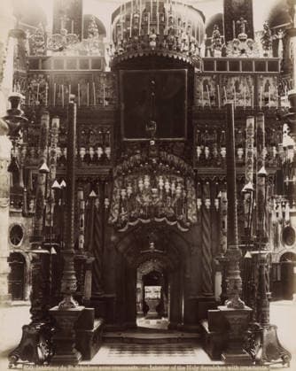 RECORD DATE NOT STATED Intà rieur du St.-Sà pulcre avec ornements. - Interior of the Holy Sepulcher with ornaments., Interior of the Church of the Holy Sepulcher in Jerusalem, photograph, Part of Travel album with photos of Jerusalem and other biblical places., inscription: ...ves No. 74 , negative number: 850 , photographer: Maison Bonfils, Jerusalem, c. 1867 - c. 1895, pasteboard, paper, albumen print, height 282 mm x width 225 mm, interior of church, Church of the Holy Sepulchre, A large ornate interior view filled with carved columns, tall decorative poles, hanging lamps, and intricately patterned panels; a central dark archway framed by twisted pillars leads inward toward a smaller altar piece visible through the opening, while above the arch are rows of o Copyright Penta Springs LCK260531_18266