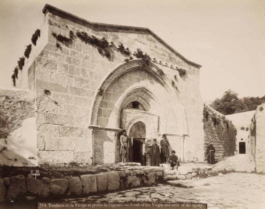 RECORD DATE NOT STATED Tomb of the Virgin Mary and the Cave of the Agony in Jerusalem, Tombeau de la Vierge et grotte de l agonie. - Tomb of the Virgin and cave of the agony., photograph, Part of Travel album with photos of Jerusalem and other biblical places., negative number: 314 , photographer: Maison Bonfils, Jerusalem, c. 1867 - c. 1895, Maison Bonfils, photographer, pasteboard, paper, albumen print, height 225 mm x width 284 mm, church (exterior), grave, tomb, cave, grotto, A stone building facade with a large arched entrance and smaller arched recesses, weathered block masonry and patches of vegetation growing on and along the upper walls; a cobbled foreground with low stone steps and a raised stone platform; several men in long garments and hats gathered Copyright Penta Springs LCK260531_18272
