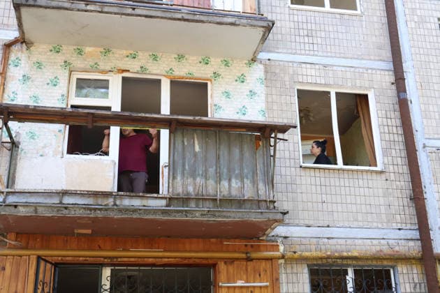 A man measures the width of a smashed balcony window in a five-storey apartment block in the Solomianskyi district that was partially destroyed by a Russian missile strike, Kyiv, Ukraine, August 1, 2026. The missile partially destroyed a five-storey apartment block, where several flats were completely burnt out. Two people were killed and eight injured. Municipal services, charities, psychologists and law enforcement officers are working at the site. Residents of damaged flats are receiving essential assistance, while the destruction is being documented for future restoration. In total, nine people were killed, more than 30 wounded, and 20 buildings damaged in Kyiv as a result of the Russian ballistic missile attack on Saturday night, Augus Copyright: xPavloxBahmutx