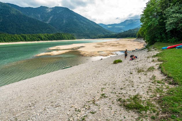 Der Wasserspiegel des Sylvensteinspeichers ist wegen anhaltender Trockenheit deutlich gesunken, breite Uferstreifen sind trocken gefallen, das Niedrigwasser sorgt für breite Kiesflächen, Bayerische Alpen, Lenggries, 7. August 2026 Deutschland, Lenggries-Fall, 7. August 2026, breite Kiesflächen am Ufer des Sylvensteinspeichers, die anhaltende Trockenheit hat den Wasserspiegel des Sylvensteinspeichers deutlich sinken lassen, breite Uferstreifen sind trocken gefallen, Niedrigwasser sorgt für einen breiten Kiesstrand, künstlicher Speichersee in den Bayerischen Voralpen bei Lenggries, Wasserspeicher zur Regulierung der Isar, Hochsommer, heißer Sommertag, Freitagnachmittag, Landkreis Bad Tölz-Wolfratshausen, Oberbayern, Sommer, Bayern