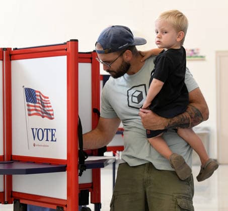 August 11, 2026, Racine, Wisconsin, USA: TYLER SCHEER, with his son CALLAHAN, 2, votes at Fratt Elementary School in Racine in the Wisconsin primary election Tuesday August 11, 2026. National focus is on the Democratic gubernatorial primary and on efforts to flip several Republican congressional seats, including that of incumbent Bryan Steil who represents the First Congressional District, including Racine County. Racine USA - ZUMAh154 20260811_znp_h154_009 Copyright: xMarkxHertzbergx