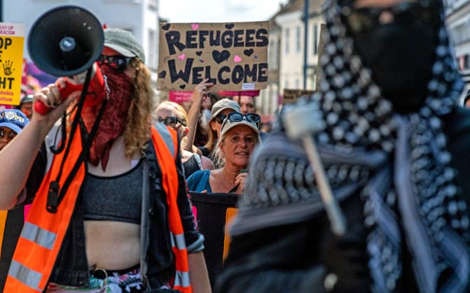 News Bilder des Tages Anti-immigration demonstrators and Stand Up to Racism counter-protesters rally in Maidstone MAIDSTONE, UNITED KINGDOM - AUGUST 15: Activists from Stand Up to Racism assemble outside County Hall in Maidstone, Kent, United Kingdom, on August 15, 2026, to counter-protest against the far-right Kent Nationalist Movement as they gathered before marching through the town center. While the far-right group voiced opposition to government border policies, asylum seeker housing programs, and mass migration, Stand Up to Racism demonstrators chanted slogans and displayed placards to denounce far-right activity and express solidarity with refugees, with police officers maintaining a presence to keep the opposing groups separated. Stuart Brock Anadolu M Copyright: x2026xAnadoluxStuartxBrockx