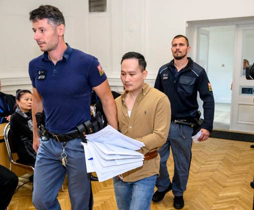 The trial in a major case involving the smuggling of migrants from Asia through the Czech Republic to Germany began today, on September 22, 2026, at the District Court in Litomerice, Czech Republic. There are 13 defendants. One of the defendants, described by the prosecutor as the main organiser of the migrant smuggling operation, is in custody. The group smuggled at least 63 refugees. If convicted, the defendants face between two and eight years in prison. The defendant, Minh Hai Duong, centre, enters the courtroom accompanied by guards. (CTKxPhoto OndrejxHajek) CTKPhotoP2026092202761 CTKPhotoP2026092202761