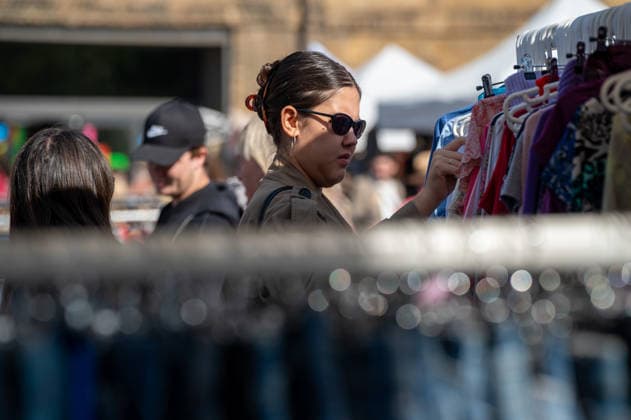 September 26, 2026, London, United Kingdom: Attendees at the King™s Cross Classic Car Boot Sale sort through racks of clothing. The Kings Cross Classic Car Boot Sale returned to Granary Square and Stable Street, King™s Cross, London, for its 11th year. Held several times throughout the year, the event brings together vintage fashion, second-hand clothing, jewellery, homewares, collectables and vinyl records alongside classic cars, motorcycles and commercial vehicles. Visitors browsed stalls and traders, with many making a special effort to dress in period clothing inspired by the 1950s, 1960s and 1970s.continuing a tradition associated with the event. London United Kingdom - ZUMAs197 20260926_aaa_s197_353 Copyright: xJamesxWilloughbyx