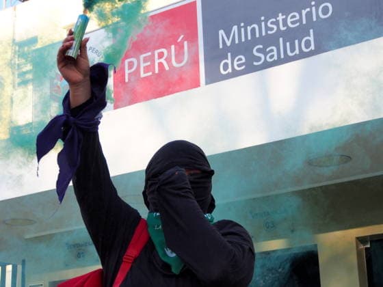 September 26, 2026, Lima, Lima, Peru: A hooded woman holds a green smoke flare in front of the Ministry of Health when on International Safe Abortion Day hundreds of women, wearing green scarf, carry out a demonstration demanding legal, safe, and free abortion in Peru, as part of the comprehensive health of girls, adolescents, women, and anyone with the possibility of gestating. Abortion in Peru, a conservative country, is illegal and punishable Lima Peru - ZUMAg240 20260926_zip_g240_021 Copyright: xCarlosxGarciaxGranthonx