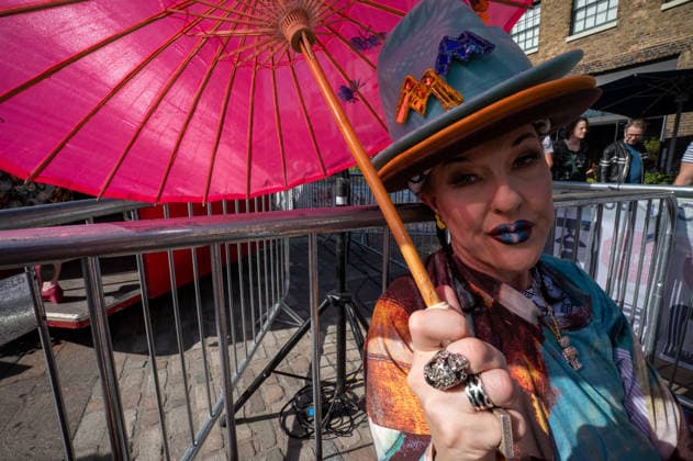 September 26, 2026, London, United Kingdom: An attendee at the King™s Cross Classic Car Boot Sale, held at Granary Square in King™s Cross, London, shades themselves from the sun beneath a parasol. The Kings Cross Classic Car Boot Sale returned to Granary Square and Stable Street, King™s Cross, London, for its 11th year. Held several times throughout the year, the event brings together vintage fashion, second-hand clothing, jewellery, homewares, collectables and vinyl records alongside classic cars, motorcycles and commercial vehicles. Visitors browsed stalls and traders, with many making a special effort to dress in period clothing inspired by the 1950s, 1960s and 1970s.continuing a tradition associated with the event. London United - ZUMAs197 20260926_aaa_s197_374 Copyright: xJamesxWilloughbyx