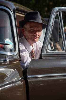 September 26, 2026, London, United Kingdom: An attendee at the King™s Cross Classic Car Boot Sale in London poses for photographs while sitting in a classic British car. The Kings Cross Classic Car Boot Sale returned to Granary Square and Stable Street, King™s Cross, London, for its 11th year. Held several times throughout the year, the event brings together vintage fashion, second-hand clothing, jewellery, homewares, collectables and vinyl records alongside classic cars, motorcycles and commercial vehicles. Visitors browsed stalls and traders, with many making a special effort to dress in period clothing inspired by the 1950s, 1960s and 1970s.continuing a tradition associated with the event. London United Kingdom - ZUMAs197 20260926_aaa_s197_369 Copyright: xJamesxWilloughbyx