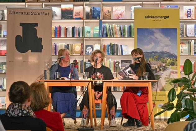 Minifestival AH0J (Literaturfestival) - Tschechien setzt über - der Kulturinitiative Literaturschiff, in der Buchhandlung Kurdirektion in Bad Ischl. Lesungen und Gespräche in Korrespondenz zum Gastauftritt Tschechiens auf der Frankfurter Buchmesse 2026. Es liest die tschechische Schriftstellerin und Magnesia Litera Preisträgerin Lucie Faulerova. Die Veranstaltung wird moderiert von Julia Miesenböck., fotografiert am 01.10.26. Das Bild zeigt v.l.n.r.: Übersetzerin Ladislava Baxant-Cenjar, Schriftstellerin Lucie Faulerova, Moderatorin Julia Miesenböck vor Publikum 2026 - Minifestival AH0J (Literaturfestival) - Tschechien setzt über - der Kulturinitiative Literaturschiff, in der Buchhandlung Kurdirektion in Bad Ischl. Lesungen und Gespr