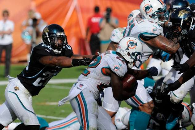 NFL, American Football Herren, USA Jaguars vs Dolphins DEC 16 December 16, 2012: Reggie Bush 22 of the Miami Dolphins tries to avoid the tackle by Dawan Landry 26 of the Jacksonville Jaguars during the NFL football game between the Miami Dolphins and Jacksonville Jaguars at Sun Life Stadium in Miami Gardens FL. The Dolphins defeated the Jaguars 24-3. Miami Gardens FL U.S. EDITORIAL USE ONLY Copyright: xx ZUMA-20121216_zaf_cd5_104.jpg JCxRidleyx csmphoto689223