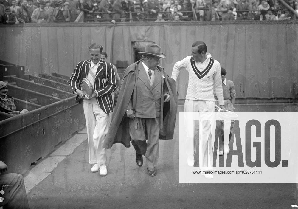 Fred Perry and Gottfried Von Cramm , with the umpire , M Redelsperger , enter the center court at Roland Garros for the finals . 2 June 1936 France