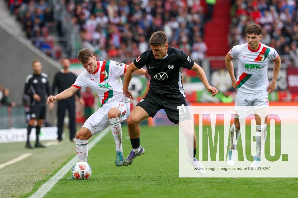 In duel, action, with Robin Fellhauer 19 FC Augsburg , Joakim Maehle 21 VfL Wolfsburg , Mert Koemuer 36 FC Augsburg , FC Augsburg vs VfL Wolfsburg, Football, 1 Bundesliga, 6 Matchday, 04 10 2025 DFB regulations prohibit any use of photographs as image sequences and or quasi video Augsburg Bayern Germany