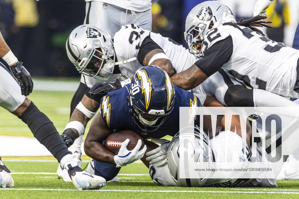 NFL, American Football Herren, USA 2025: Los Angeles Chargers 31:14 Las Vegas Raiders Los Angeles Chargers running back Kimani Vidal 30 is tackled by the Las Vegas Raiders during an NFL football game at SoFi Stadium, Sunday Nov. 30, 2025, in Inglewood, Calif. Los Angeles United States