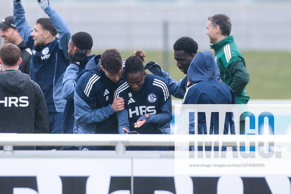 Football training of FC Schalke 04 v l Dejan Ljubicic FC Schalke 04 , Moussa Ndiaye FC Schalke 04 , Zaid Tchibara FC Schalke 04 are watching something on their smartphones Gelsenkirchen training ground FC Schalke 04 NRW Germany xRHR PHOTO YYx