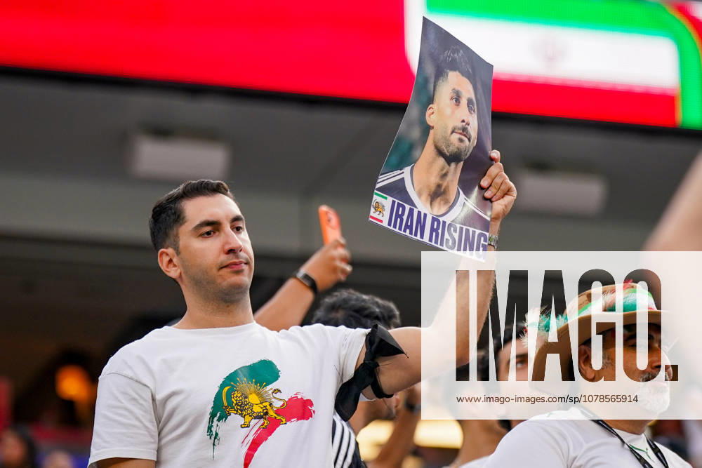 USA Soccer 2026 FIFA World Cup Group Stage Group G Iran vs. New Zealand SoFi Stadium, Inglewood, Los Angeles County, California An Iranian fan watches the World Cup match from the stands and holds aloft a portrait photo of a soccer player with the inscription Iran Rising. The image reflects support for the Iranian opposition, the protest movement, and the political identity of Iranians in exile. The historic lion and sun symbolism is seen as a sign of resistance against the Islamic Republic,detected_source_language