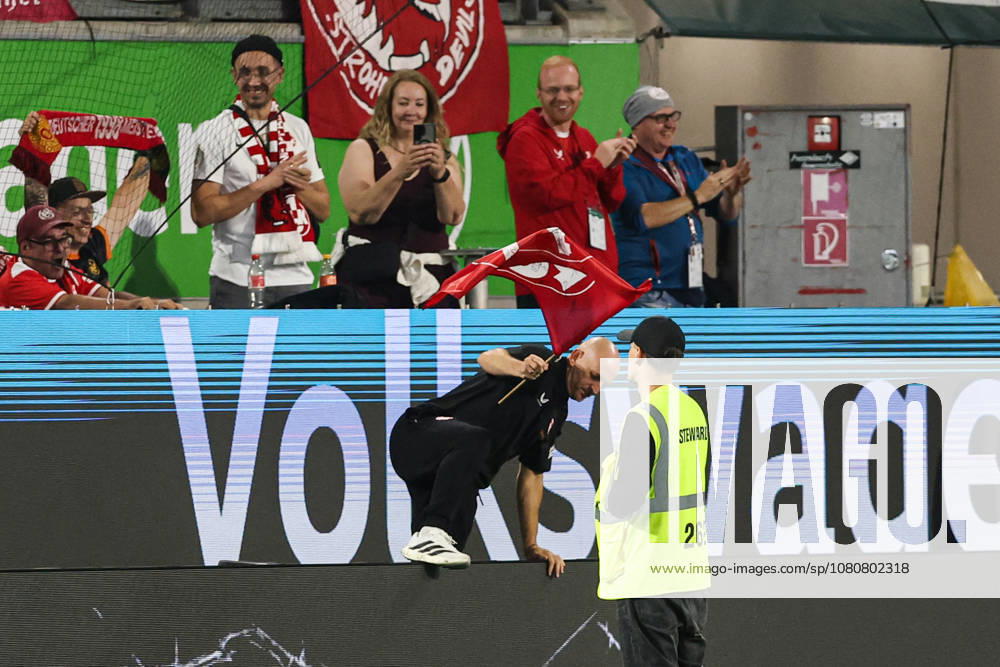 Coach Torsten Lieberknecht of 1. FC Kaiserslautern holding a 1. FC Kaiserslautern flag after the final whistle of the 2026–2027 Bundesliga match between VfL Wolfsburg and 1. FC Kaiserslautern at the Volkswagen Arena in Wolfsburg. Soccer, Man,Men, Germany