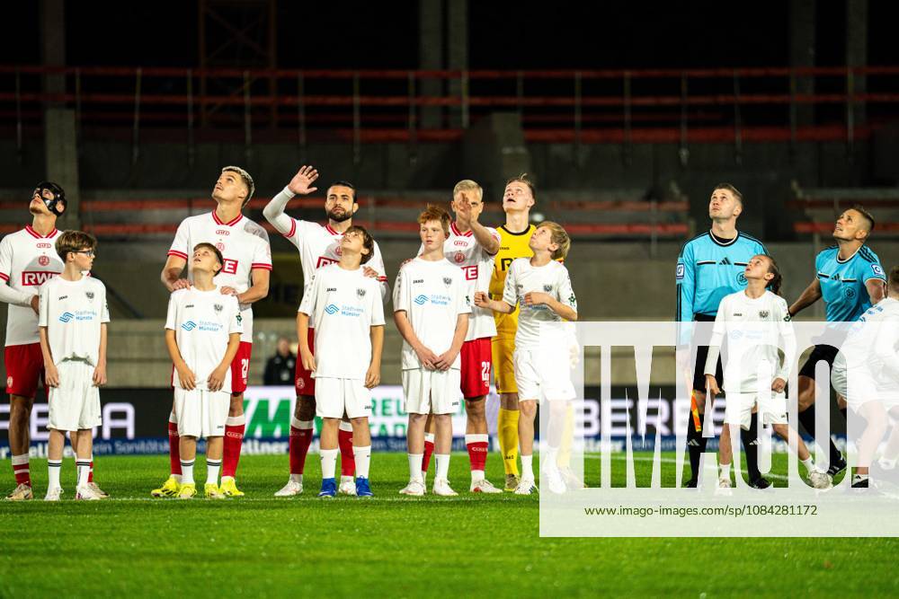 3rd Division, Matchday 8, SC Preußen Münster vs. Rot Weiss Essen at the LVM Preußenstadion; the team looks up at the pyrotechnics. IMPORTANT NOTICE: In accordance with DFB and DFL regulations, it is prohibited to use or allow the use of photographs taken in the stadium and or during the game in the form of sequential images and or video-like photo sequences