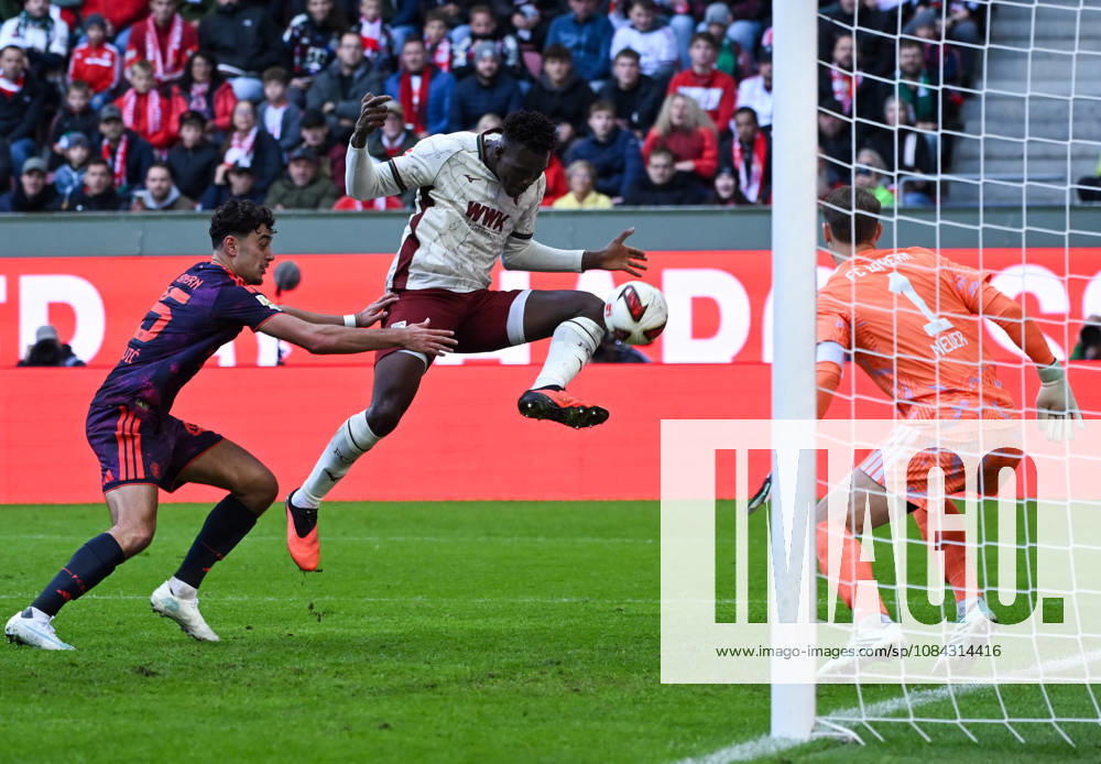 Soccer, Bundesliga 1, FC Augsburg vs. Bayern Munich: Aleksandar Pavlovic (FC Bayern Munich), Juma Bah (FC Augsburg), Manuel Neuer, FC Bayern Munich, tackle, action, battle for the ball. DFL and DFB regulations prohibit any use of photographs as image sequences and or quasi-video. Augsburg