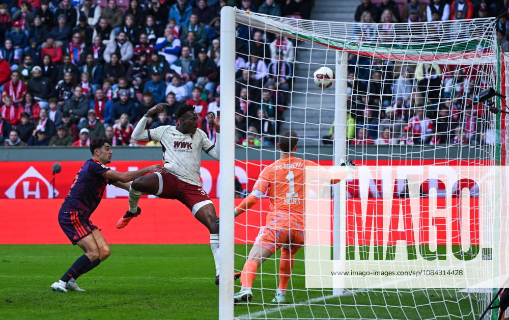Soccer, Bundesliga 1, FC Augsburg vs. Bayern Munich: Aleksandar Pavlovic (FC Bayern Munich), Juma Bah (FC Augsburg), Manuel Neuer, FC Bayern Munich, tackle, action, battle for the ball. DFL and DFB regulations prohibit any use of photographs as image sequences and or quasi-video. Augsburg