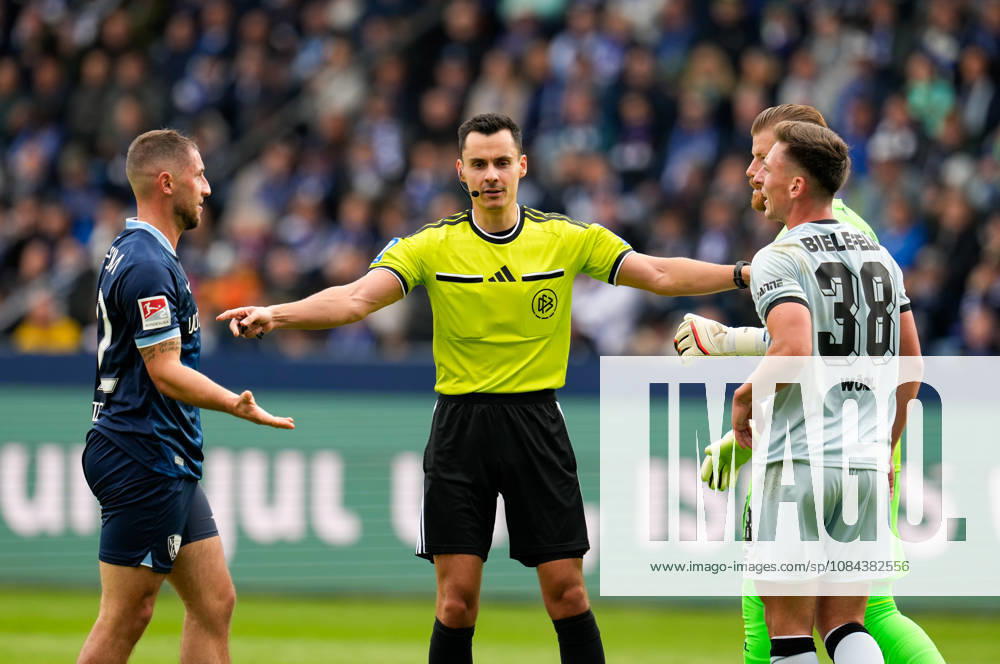 Referee Konrad Oldhafer discusses the play with Maximilian Wittek of VfL Bochum 1848 (No. 32) and Marius Woerl of DSC Arminia Bielefeld (No. 38) following physical contact. GER, VfL Bochum 1848 vs. DSC Arminia Bielefeld, 2. Bundesliga, Matchday 7, 2026–27 season, Vonovia Ruhrstadion, Bochum, October 11, 2026. DFL regulations prohibit any use of photographs as image sequences and or quasi-video. VfL Bochum 1848 vs. DSC Arminia Bielefeld, 2. Bundesliga, Matchday 7, 2026–27 Season, October 11, 2026, Bochum