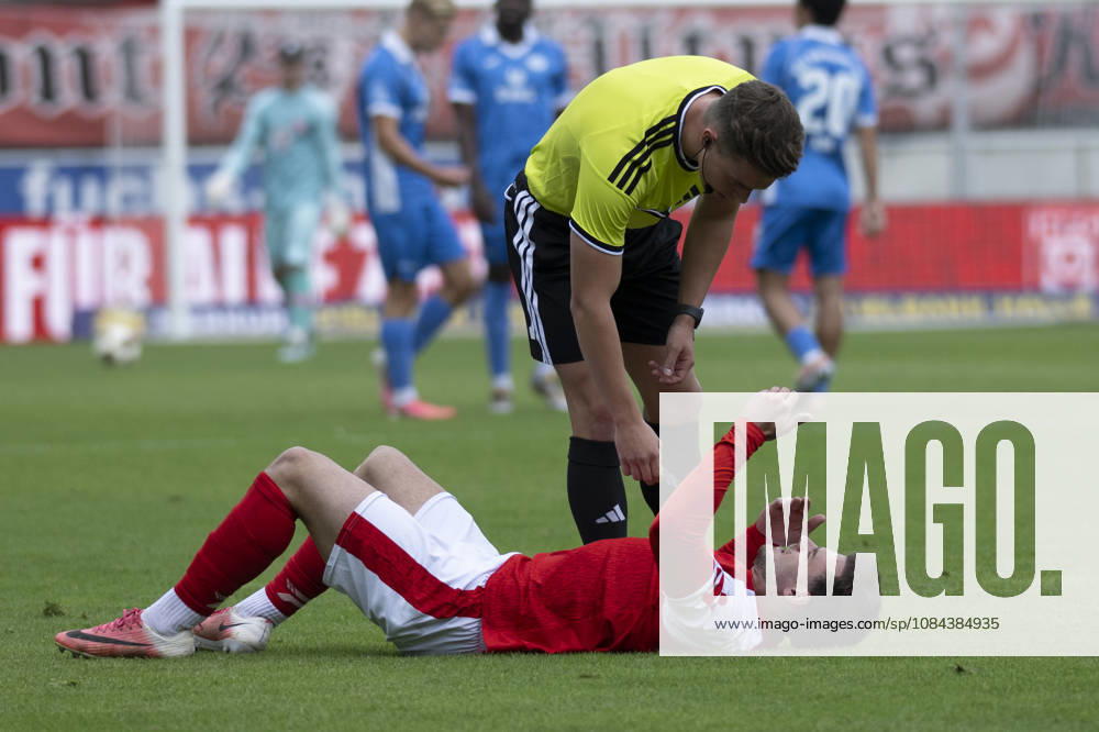 Regionalliga Nordost, Season 26-27: Hallescher FC vs. RSV Eintracht 1949 e.V., Halle, Germany, October 11, 2026. Pictured, from left: Max Kulke (Halle) – injured, injury, pain – and referee Oskar Laempel at the Halle Saale Leuna Chemie Stadium, Saxony-Anhalt, Germany
