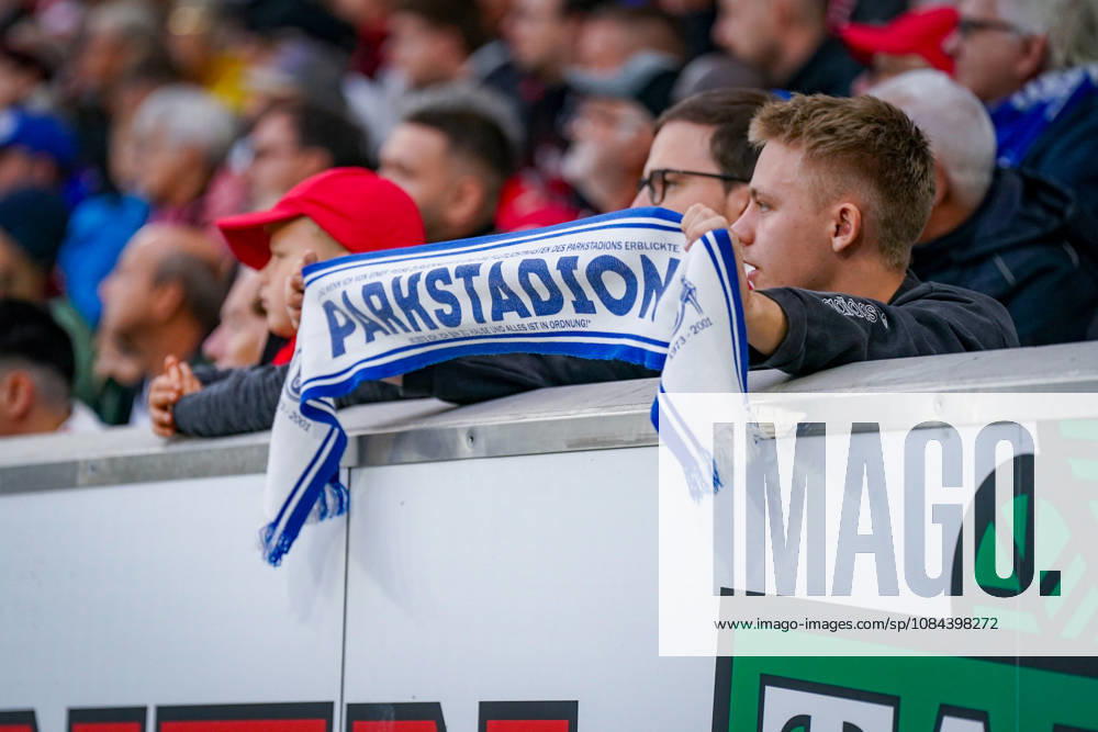 Germany Soccer Bundesliga 2026–2027, Matchday 5: SC Freiburg vs. FC Schalke 04, Europa-Park Stadium, Freiburg. A young FC Schalke 04 fan holds up a blue-and-white fan scarf bearing the inscription PARKSTADION in the stands of the Europa-Park Stadium during the away game against SC Freiburg. Schalke 04, S04, Royal Blue, Parkstadion, stadium history, tradition, nostalgia, fan culture, fan scene, visiting fans, away fans, fan scarf, fan merchandise, spectators, stands, soccer, Bundesliga, SC Freiburg, SCF, Gelsenkirchen, Freiburg, stadium, interior view, close-up