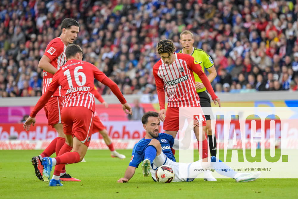 Kenan Karaman (FC Schalke 04, 19) is sitting on the ground with the ball, locked in a duel with Viktor Matanovic (SC Freiburg, 31) and Yannik Engelhardt (SC Freiburg, 16), Yuito Suzuki (SC Freiburg, 14 GER), SC Freiburg vs. Schalke 04, soccer, Bundesliga, Matchday 5, 2026–2027 season, October 11, 2026. DFL and DFB regulations prohibit any use of photographs as image sequences and or quasi-video. GER, SC Freiburg vs. Schalke 04, Soccer, Bundesliga, Matchday 5, 2026–2027 Season, October 11, 2026, Freiburg