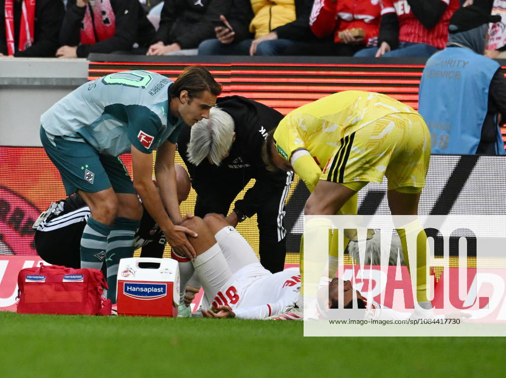 Soccer, Bundesliga 1, 1. FC Köln vs. Borussia Mönchengladbach: Ellyes Skhiri of 1. FC Köln lies injured on the ground; Florian Neuhaus (left, Borussia Mönchengladbach) and Marvin Schwäbe (right, 1. FC Köln)