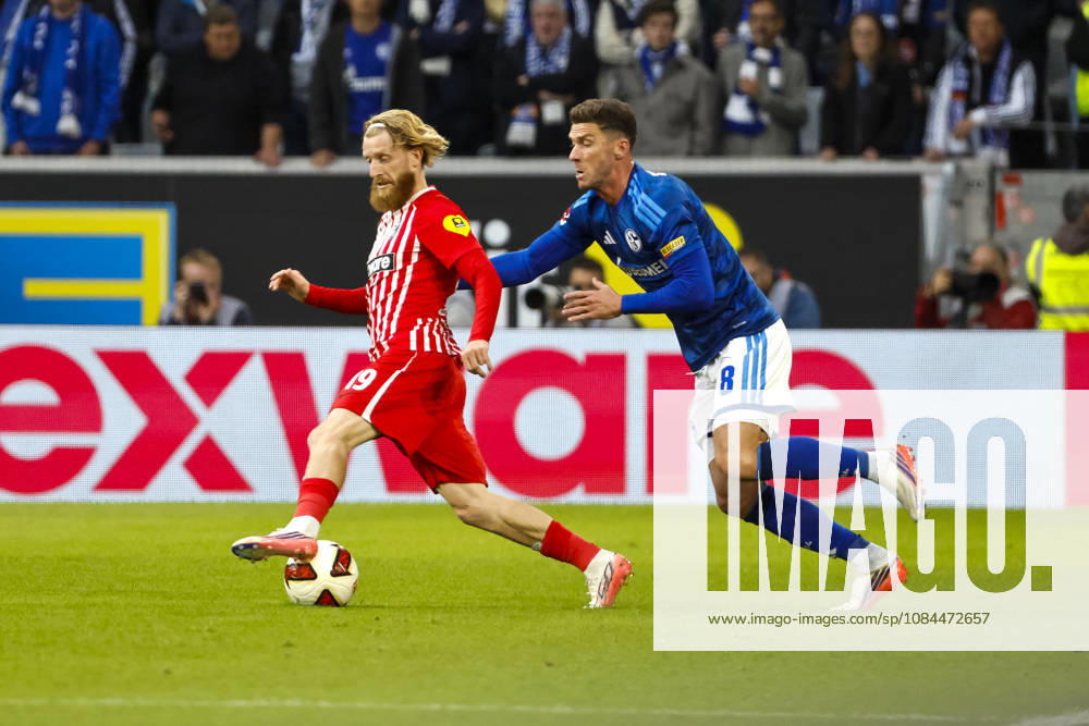Niklas Beste of SC Freiburg, 19, and Robin Gosens of FC Schalke 08 in a tackle, Germany, soccer, Bundesliga 1, Matchday 5, 2026–2027, SC Freiburg vs. FC Schalke 04, October 11, 2026, Freiburg im Breisgau, Europa-Park Stadium, Germany