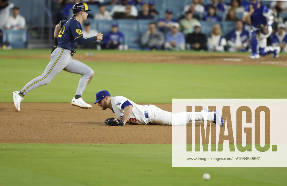 Los Angeles Dodgers third baseman Max Muncy (13) dives for a sharp grounder by Milwaukee Brewers Joey Ortiz as Brewers Cooper Pratt races past to score in the ninth inning in the MLB, Baseball Herren, USA National League Championship Series playoffs at Dodger Stadium in Los Angeles, California, on Wednesday, October 14, 2026. LAP20261014742 CAROLINExBREHMAN