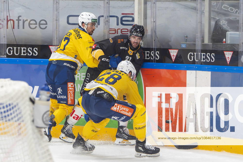 LUGANO, SWITZERLAND OCTOBER 16 Zach Sanford of Lugano (C) against Ken Jager of Davos (L) and Martin Gernat of Davos (R) during the game between HC Lugano and HC Davos at the Corner Arena on October 16, 2026, in Lugano, Switzerland. Lugano, Ticino, Switzerland