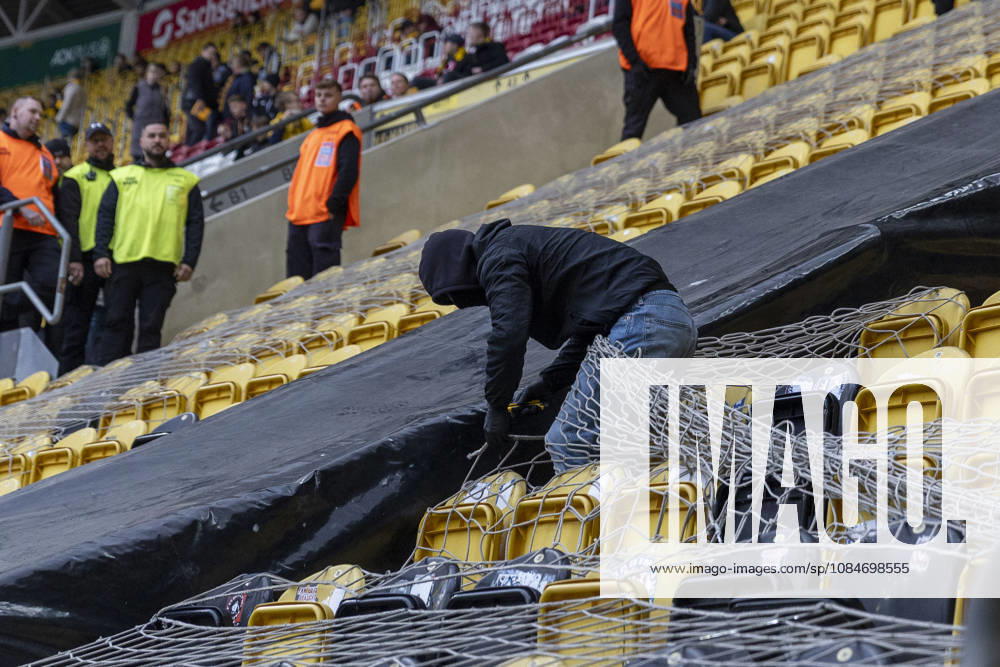 GER, Dresden, Soccer, 2. Bundesliga, Matchday 8, Dynamo Dresden vs. 1. FC Magdeburg: Pictured, from left, a masked Magdeburg fan destroys the netting of the fan section with a utility knife; Buffer Block 18, October 10, 2026, Rudolf Harbig Stadium, Dresden. DFL and DFB regulations prohibit any use of photographs as image sequences and or quasi-video,