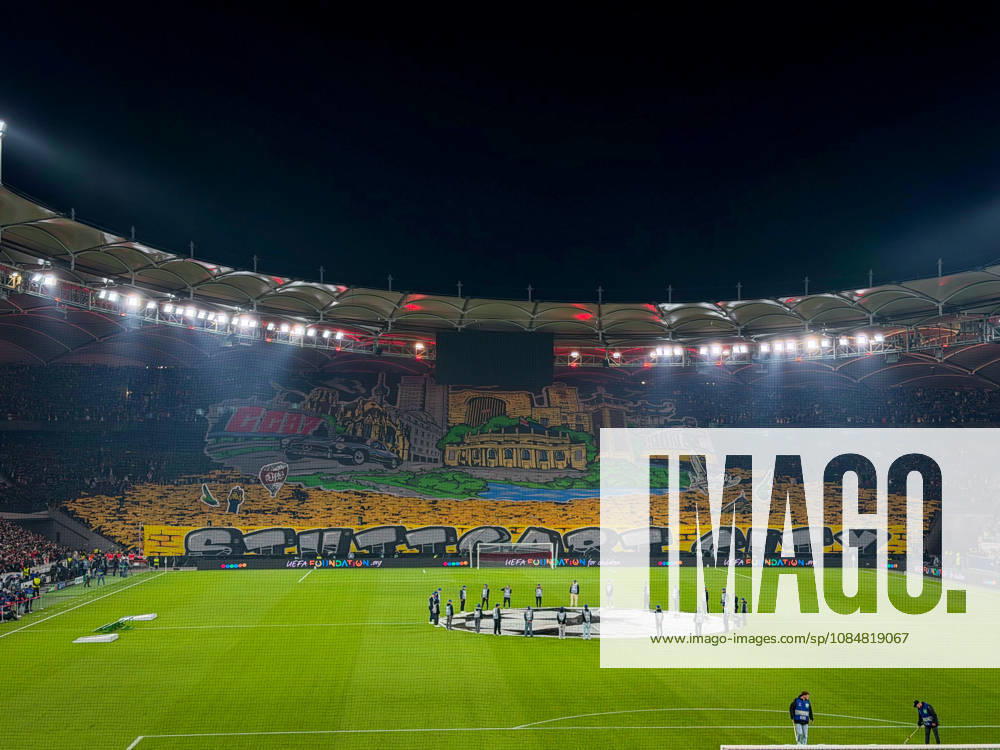 Germany, Soccer, 2026–2027 UEFA Champions League, Matchday 3, VfB Stuttgart vs. Atlético Madrid, October 20, 2026, Stuttgart Arena, interior view; wide shot of the illuminated soccer stadium from behind the goal before kickoff; large fan choreography by VfB supporters in the Cannstatter Kurve; packed stands; spectators; fans; floodlights; stadium roof; playing field; center circle; Champions League anthem, player entrance ceremony, fan section, atmosphere, home game, UEFA, Champions League, advertising, sponsors