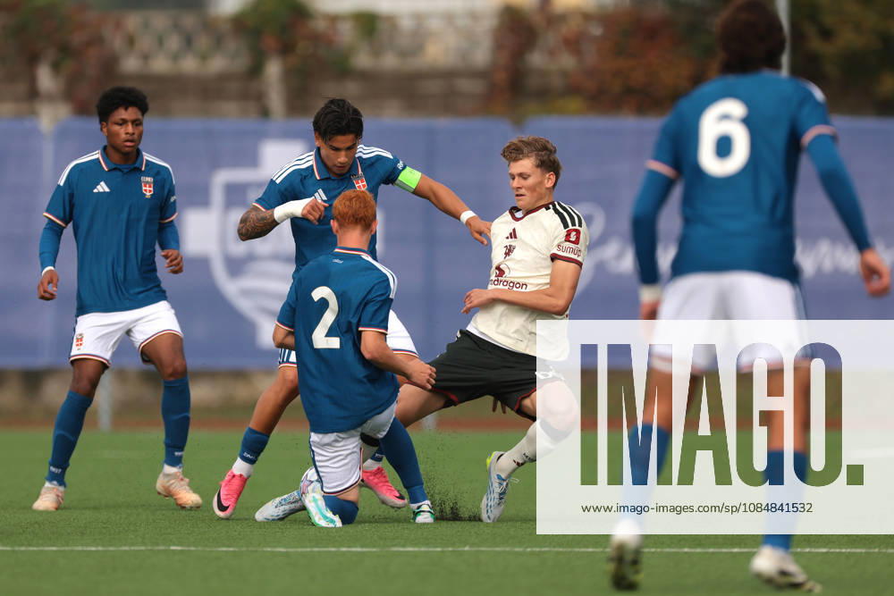 Como 1907 v Manchester United, ManU - UEFA Youth League - Campo Sportivo Comunale Angelo Volonte Rovello Porro, Italy, 21st October 2026. Albert Mills of Manchester United is outnumbered by Kevin Fustini, Francesco Andrealli and Ettore Broggian of Como 1907 during the Como 1907 vs Manchester United UEFA Youth League, League phase match at Campo Sportivo Comunale, Angelo Volonte, Rovello Porro. Picture credit should read: Jonathan Moscrop Rovello Porro Campo Sportivo Comunale Angelo Volonte Italy