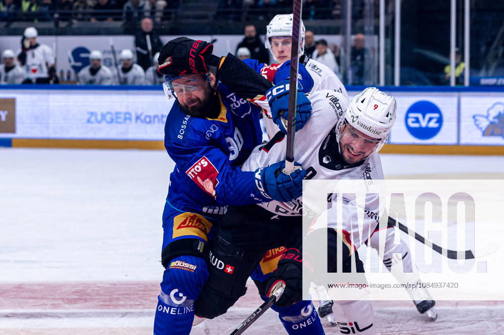 Damien Riat 9 of Lausanne HC fights tooth and nail against Tomas Tatar 90 of EV Zug on October 23, 2026, National League, Regular Season, Ice Hockey, OYM Hall, Zug EV Zug vs. Lausanne HC. Image by